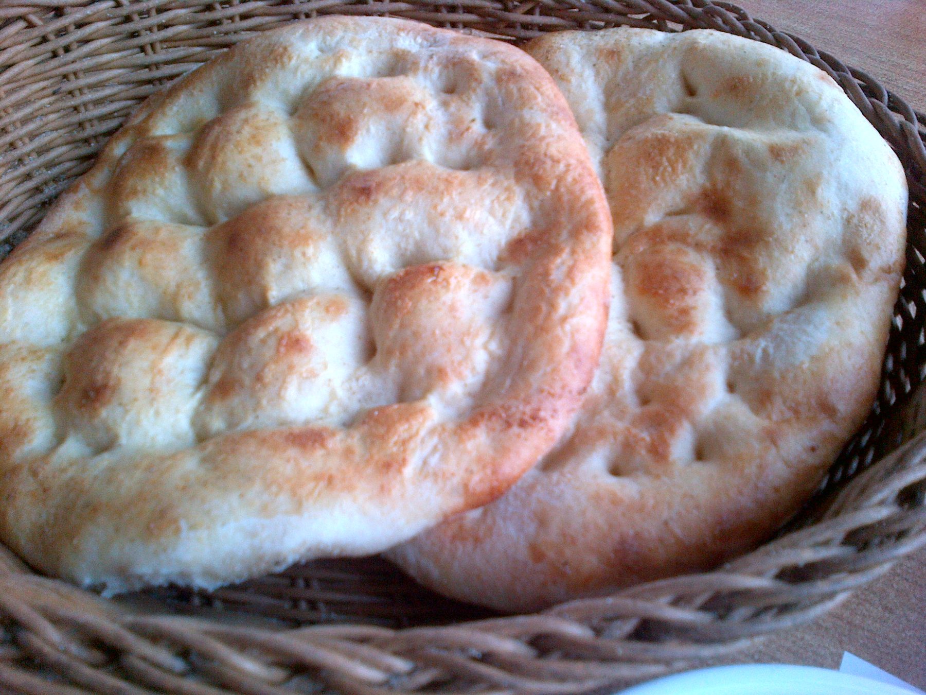 Round Turkish pide flatbread with a dimpled center and browned rim