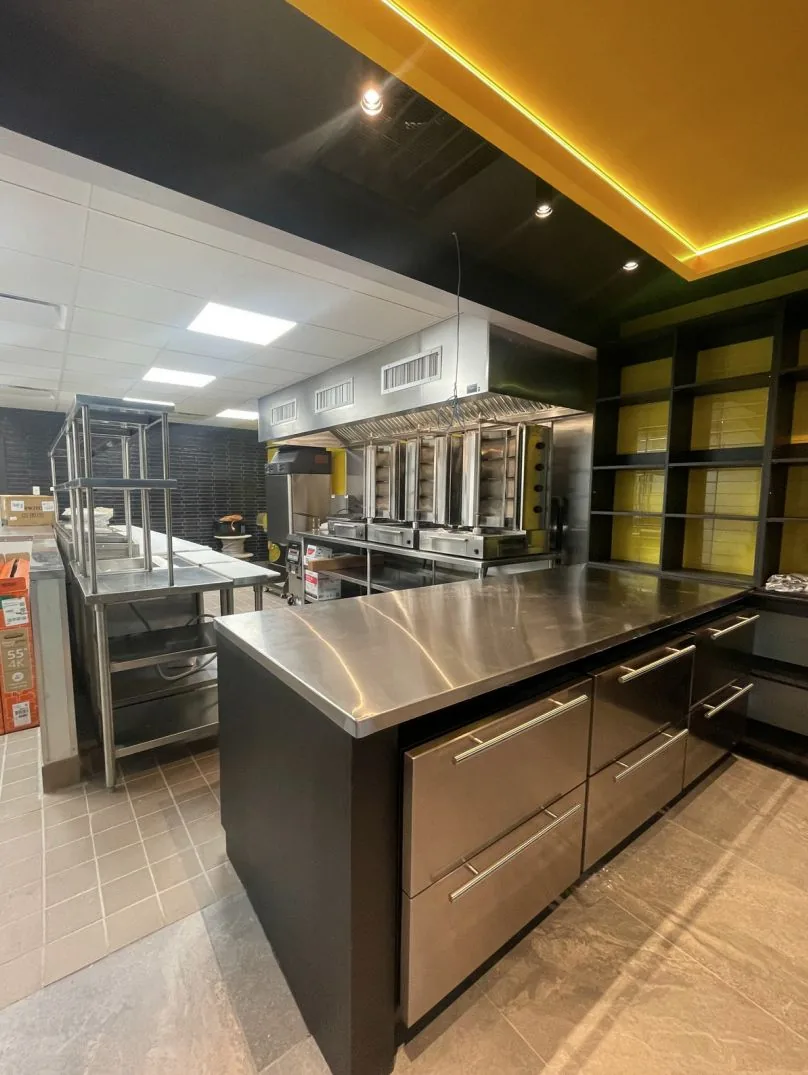A döner line at night, the rotisserie glowing behind the counter