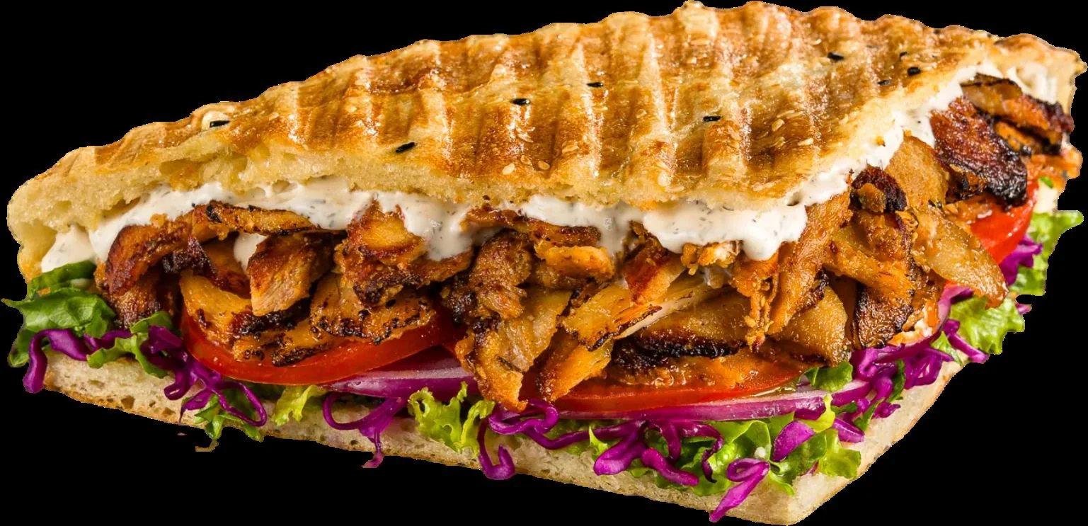 A German döner sandwich in toasted pide, shown against black